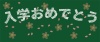 黒板にチョークで「入学おめでとう」の文字と桜の花びらを描いたイラスト